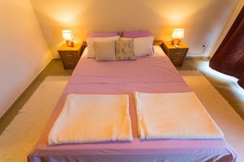 a bedroom with a large bed with two lamps at Fresh & spacious studio in Dubrovnik