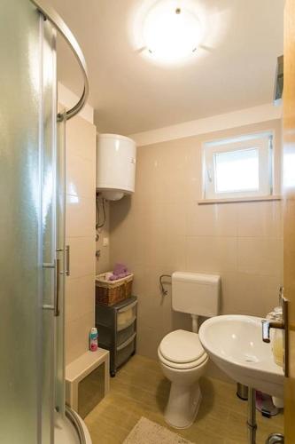 a small bathroom with a toilet and a sink at Fresh & spacious studio in Dubrovnik