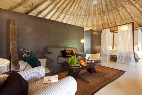 ein Wohnzimmer mit einer Couch und einem Tisch in der Unterkunft Hotel Les Cinq Djellabas in Douar Caïd Layadi