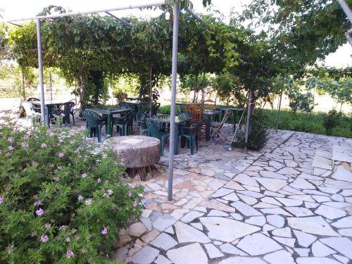 a patio with tables and chairs under an umbrella at Rexhos Studios in Himare