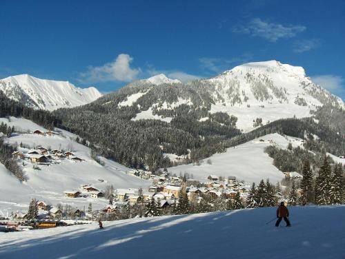 a person is skiing down a snow covered mountain at Trendapartment in Russbach am Pass Gschütt