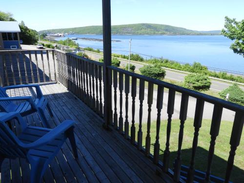 a deck with two chairs and a view of the water at Admiral Digby Inn Restaurant and Cottages in Digby