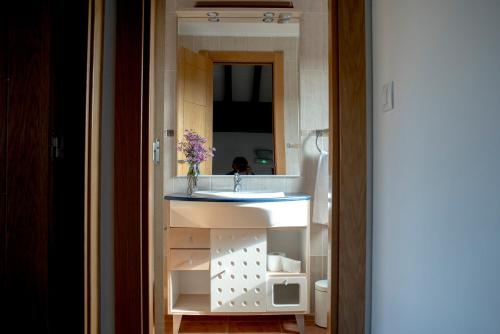 a bathroom with a sink and a mirror at The Cantabrian Apartamentos in Serdio