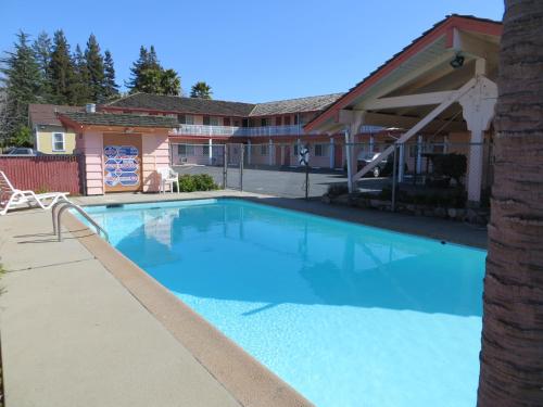 une grande piscine bleue en face d'un bâtiment dans l'établissement National 9 Motel, à Santa Cruz