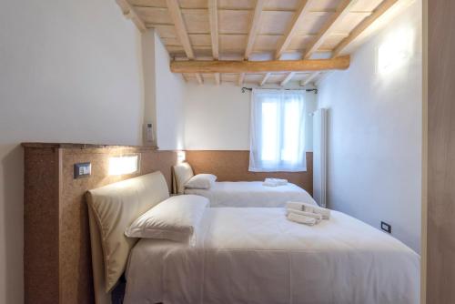 two beds in a room with white sheets at Il Limone in Florence