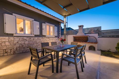 a patio with a table and chairs and a fireplace at Amygdalia Villa in Pandokrátor