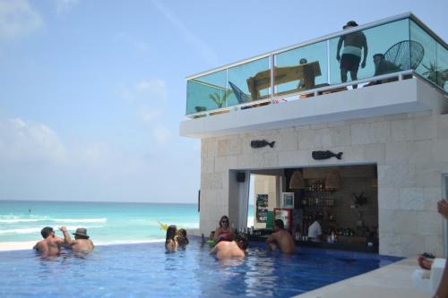 a group of people in a swimming pool near the beach at Ocean View Condo in Cancún
