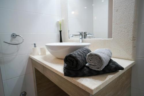 a bathroom with a sink and towels on a counter at Apartments Aurora in Zadar