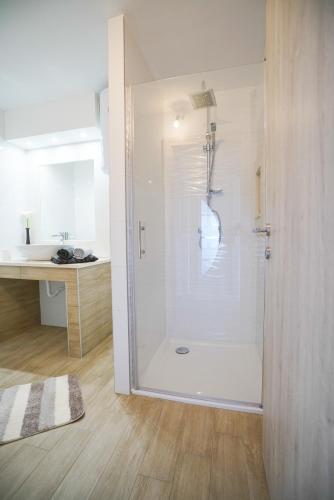 a white bathroom with a shower and a sink at Apartments Aurora in Zadar