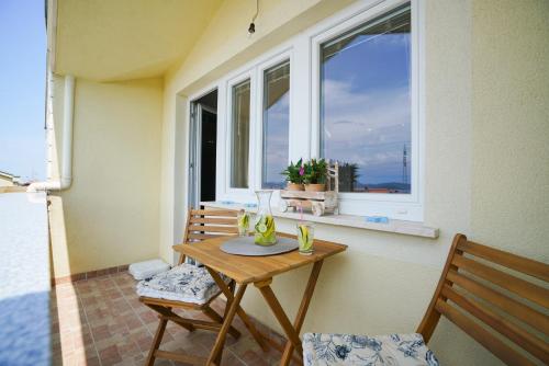 a table and two chairs in front of a window at Apartments Aurora in Zadar