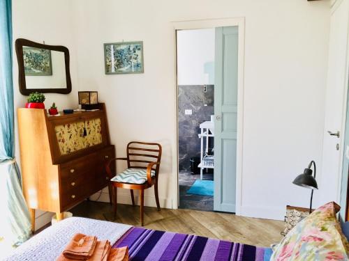 - une chambre avec un lit et une chaise à côté d'une porte dans l'établissement Gò Gò House, à Palerme