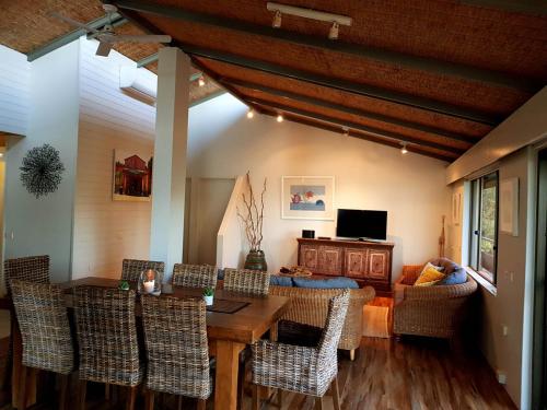 a living room with a wooden table and chairs at Nautilus Beachfront Villas & Spa in Coffs Harbour