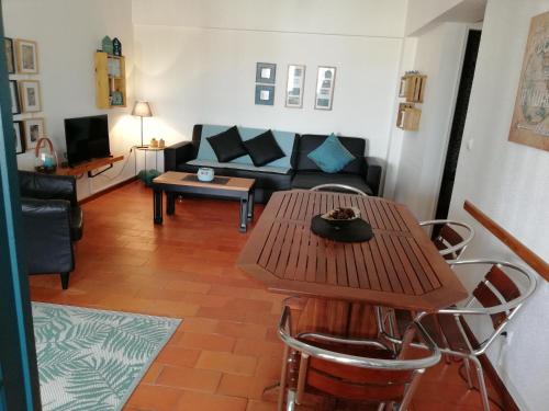 a living room with a table and a couch at Apartamento con vistas al Guadiana in Vila Real de Santo António