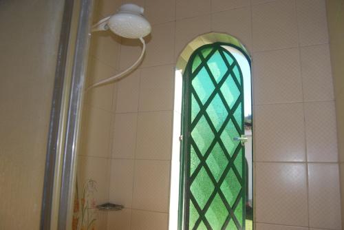 uma casa de banho com um chuveiro e uma janela de vidro verde em Radicais Natureza em Monte Alegre do Sul