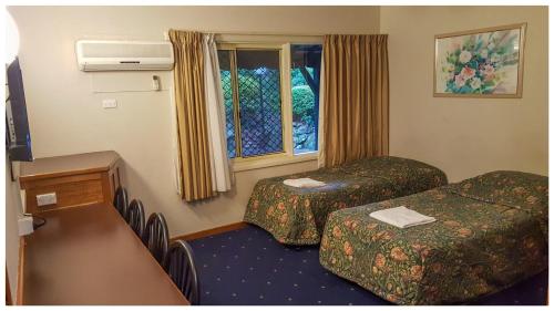 Habitación de hotel con 2 camas y ventana en Ascot Motor Inn, en Hornsby