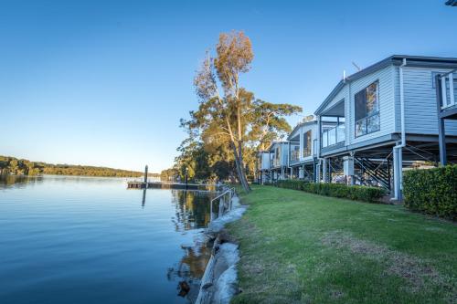 a house on the side of a body of water at Jervis Bay Holiday Park in Huskisson