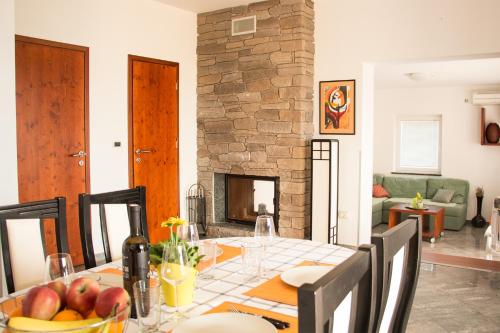 een eetkamer met een tafel en een open haard bij Lukovo Seafront Apartments in Lukovo