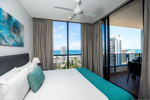 een slaapkamer met een bed en een groot raam bij Synergy Broadbeach - Official in Gold Coast