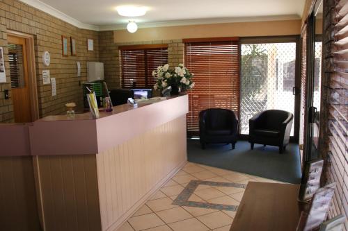 an office with a reception desk and two chairs at Macintyre Motor Inn in Goondiwindi