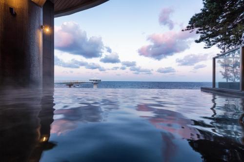 a swimming pool with a view of the ocean at Shirahama Key Terrace Hotel Seamore in Shirahama