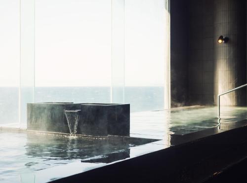 a bath tub with a fountain in the middle of a building at Shirahama Key Terrace Hotel Seamore in Shirahama