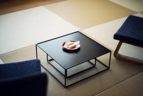 a black coffee table with a bowl on top of it at Shirahama Key Terrace Hotel Seamore in Shirahama