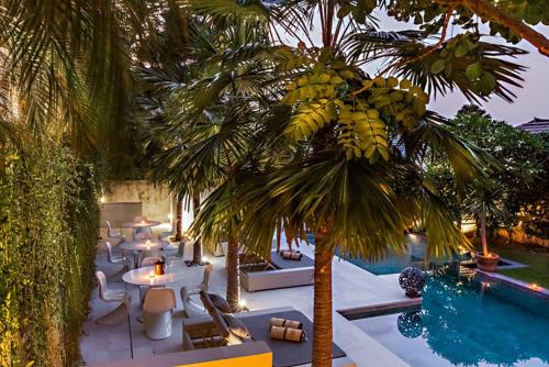 a bunch of bananas hanging from a palm tree next to a pool at Petitenget 501 in Seminyak