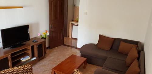 a living room with a couch and a flat screen tv at LeBovallon B&B in Mahébourg