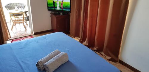 a room with a blue bed with a towel on it at LeBovallon B&B in Mahébourg