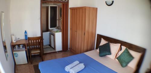 a bedroom with a bed with blue sheets and pillows at LeBovallon B&B in Mahébourg