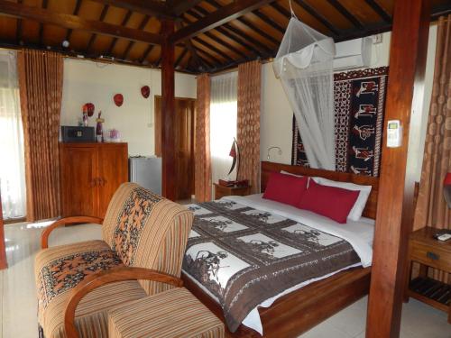 a bedroom with a bed and a chair at Alamanda Family Villas, Pool & Local Tours in Yogyakarta