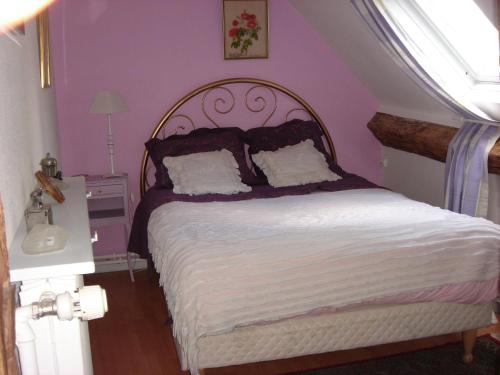 a bedroom with a large bed with purple walls at vegas in Mer