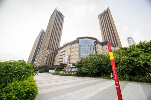 a sign in front of a building with tall buildings at Xing Yu Legend Service Apartment Canton Fair Branch in Guangzhou