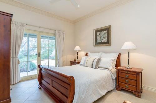 a bedroom with a bed and a window at Barossa Vineyard Cottages in Bethany