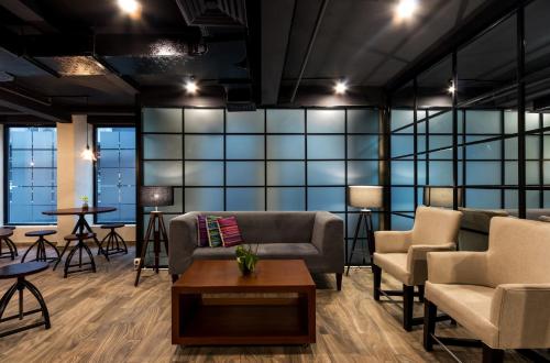 a waiting room with couches and chairs and tables at S Loft Manado in Manado