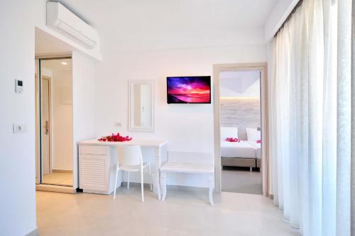a white dining room with a table and a bed at Apollon Windmill Boutique Hotel - Adults Only in Kos Town