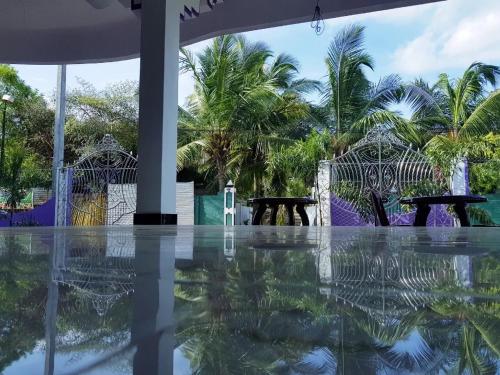 a view of a pool with tables and palm trees at SNP Star Guest House in Trincomalee