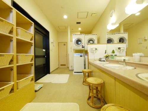 baño grande con 2 lavabos y nevera en Hotel Route-Inn Tsubamesanjo Ekimae, en Sanjo