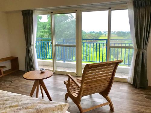 a room with a bed and a chair and a balcony at 飲山風民宿 in Jian