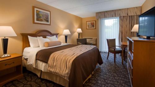 a hotel room with a bed and a flat screen tv at Best Western Clifton Park in Clifton Park