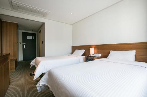 Ένα ή περισσότερα κρεβάτια σε δωμάτιο στο Busan Tourist Hotel