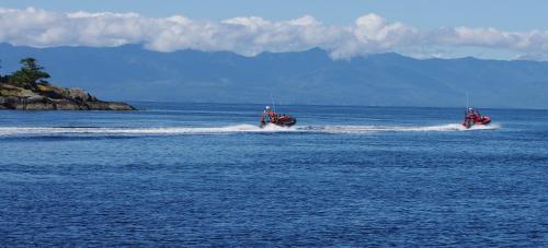 two boats on the water in the ocean at Salty Towers Ocean Front Cottages in Sooke