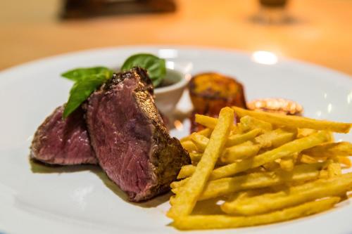 een steak en frietjes op een wit bord bij Last Frontier Beach Resort - Adults Only in El Nido