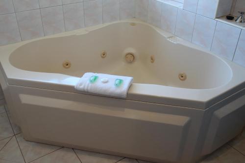 a bath tub with a towel on the side of it at Hume Villa Motor Inn in Melbourne