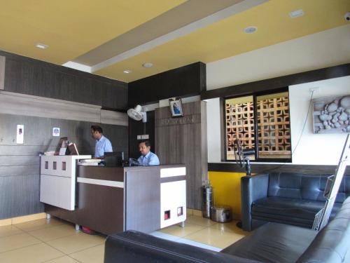 two men working at a counter in a restaurant at Devis Grand in Pondicherry