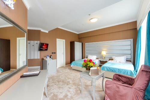 a hotel room with two beds and a living room at Phoenicia Grand Hotel in Bucharest