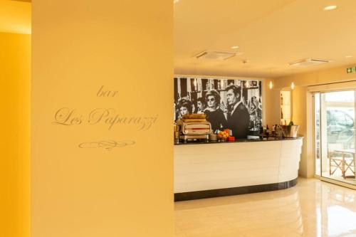a yellow wall with a bar with a sign on it at La Dolce Vita Hotel in Menton