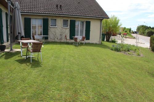 a yard with a table and chairs and a house at Villa Hotel in Troyes