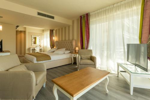 a hotel room with a bed and a living room at La Dolce Vita Hotel in Menton