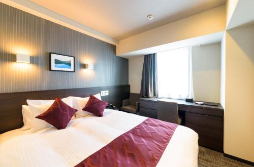 a hotel room with a bed and a desk at Best Western Plus Hotel Fino Chitose in Chitose